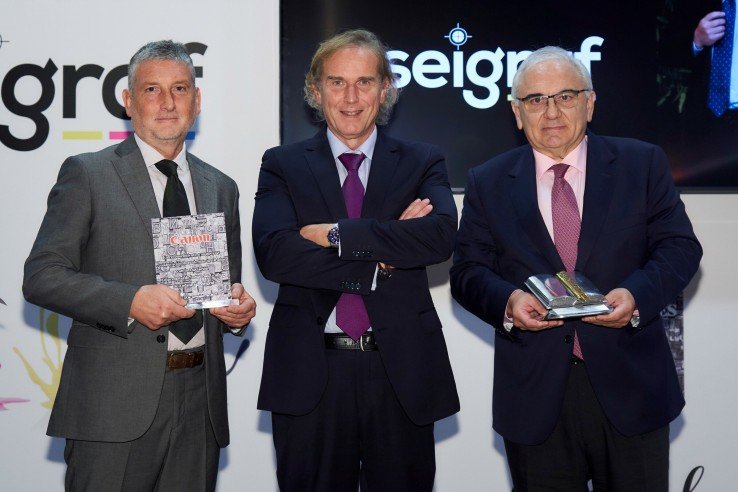 Enrique López, presidente de Aseigraf, con los dos galardonados este año: Jesús Alarcón (derecha) y Francisco Cachinero, de Canon, que recogió el reconocimiento otorgado al fabricante.